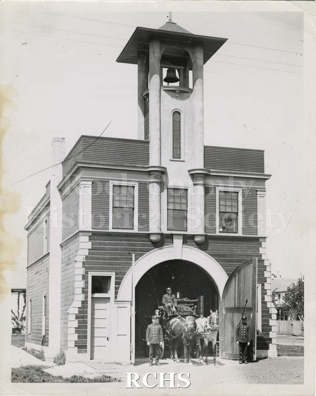 Black and white photograph of Hose Co. #3, Spring Brook Fire House. Shows a horse-drawn fire wagon posing in the entrance of the fire house.