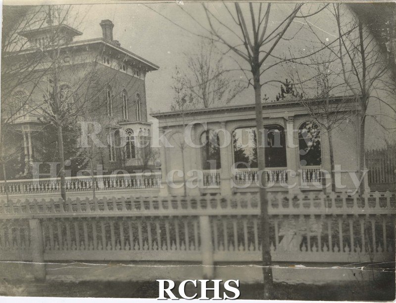 Black and white photograph of the Tallman House. Shows a gate to the right side.