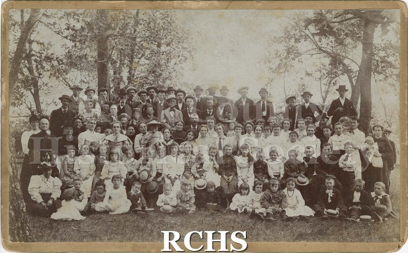 Black and white photograph of two schools picnic, Hugunin and District # 3, c.1890. Shows students at a picnic, circa 1890. Outdoors, many trees.