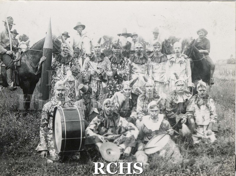 Black and white photograph of performers in the Nonesuch Brothers Parade, 1904. Soldiers or cowboy performers stand at the back on horses.
