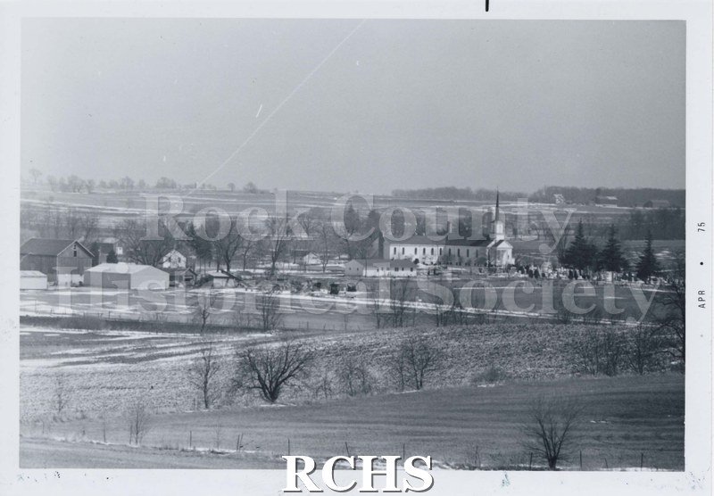 Black and white photograph of the Newark, Luther Valley environs. Shows a field with a church with steeple and graveyard.