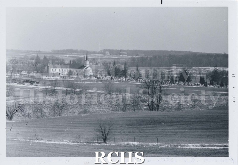 Black and white photograph of the Newark, Luther Valley Church and Cemetery. Fields surround the building. Farm in distances. "APR. 75" printed on one side.