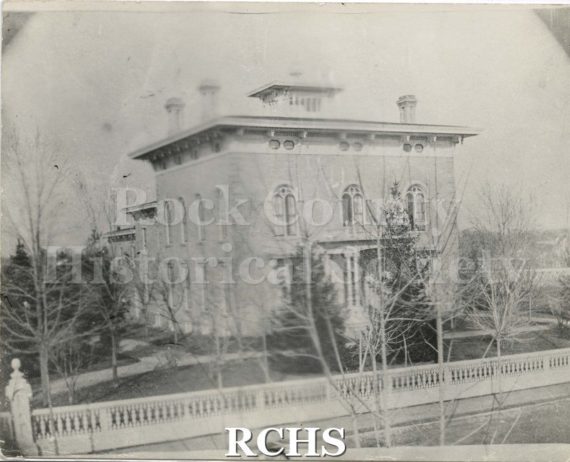 Black and white photograph of the Tallman House from the front. Fence visible, bare trees.