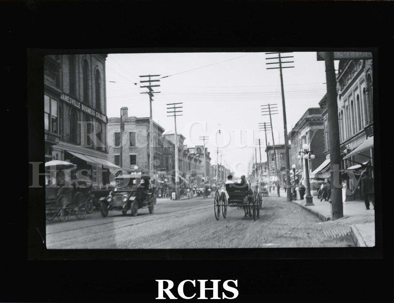 Black and white photograph of Janesville power poles. Shows newer taller power poles in downtown Janesville.