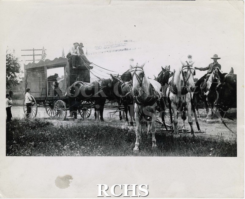 Black and white photograph of Nonesuch Brothers Circus wagon and team of horses containing bear and attendant.