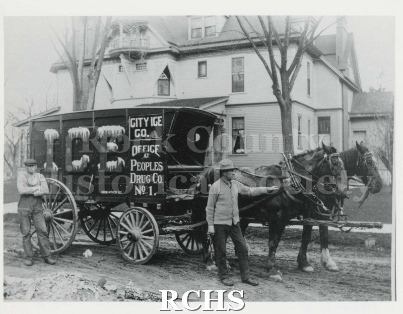 Black and white photograph of City Ice Co. 1909. Shows a team of horses hitched to a wagon. On the wagon is a sign: "City Ice Co. Office at Peoples Drug Co. No. 1".