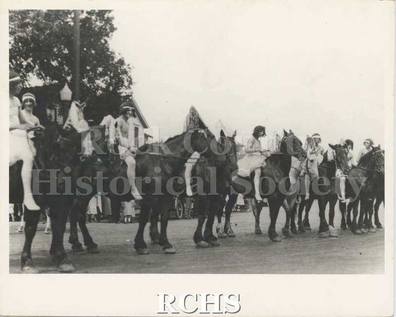 Black and white photograph of the Nonesuch Brothers Parade featuring people in costume mounted on horseback.