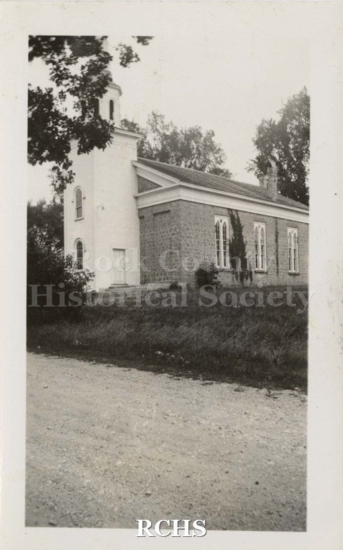 Black and white photograph of Shopiere Congregational Church. It is a side view of the church with the tower and steeple on the left side.