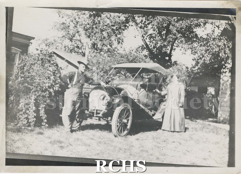 Black and white photograph of Mr. and Mrs. C. W. Kemmerer. A man and a woman are pictured standing by a vintage automobile.