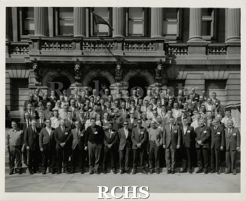 Black and white photograph of University Extension. Men are standing in front of a building.