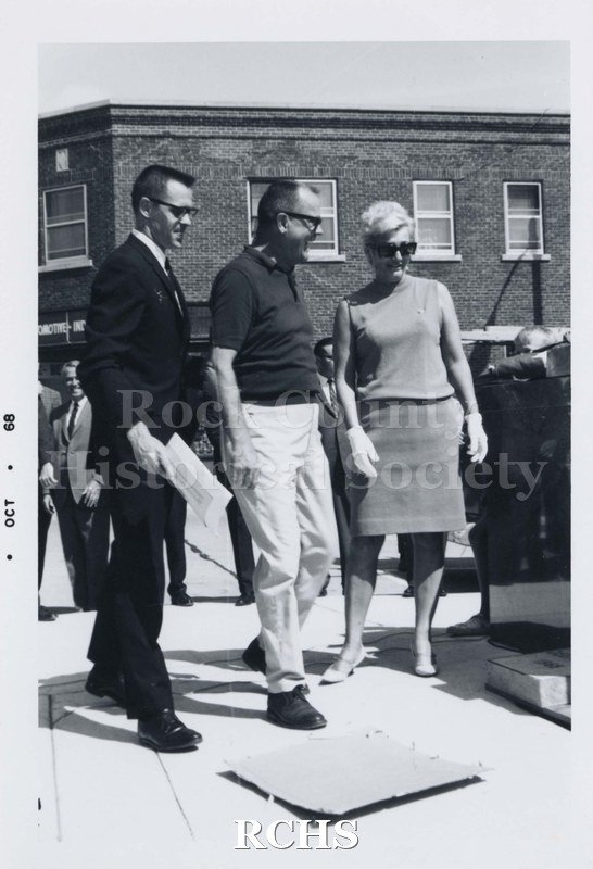Black and white photograph of three unidentified people; two men and one woman, standing on the City Hall terrace.