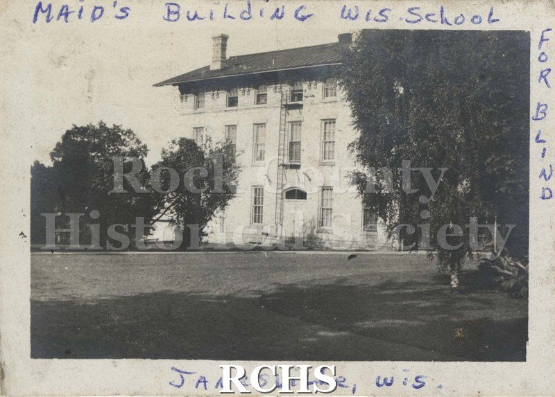Black and white photograph of the Maid's Building, Wisconsin School for the Blind, Janesville, Wis." Shows a three story building with fire escape and two chimneys.