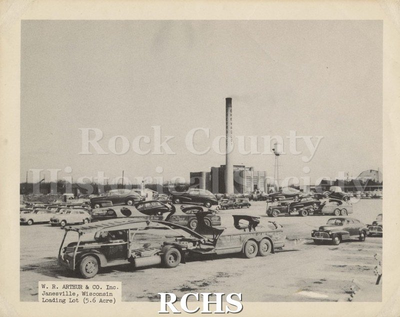 Black and white photograph of W. R. Arthur & Co. Shows a transport truck and trailer in front of the lot and other carriers in the background.