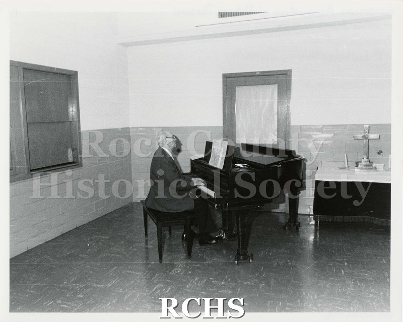 Black and white photograph of Carl Bloedow playing a grand piano.