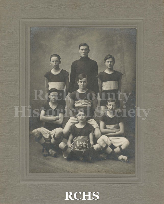 Black and white photograph of Junior 1911-1912 Champions. Six young boys and a coach are pictured.