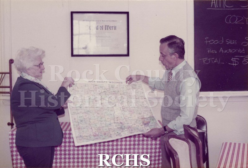 Colored photograph of Mildred Rye and Maurice Montgomery holding a map.