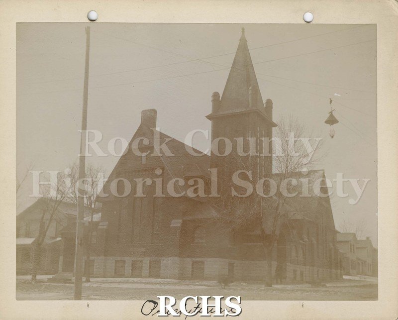 Black and white photograph of Presbyterian Church, Janesville, WI. Shows an early church building with a bell tower on it. . On bottom: "Presbyterian".