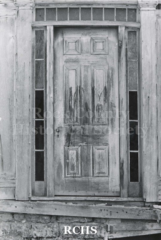 Black and white photograph of Hodson House, Shopiere Road. Shows a farmhouse door showing deterioration from the elements.