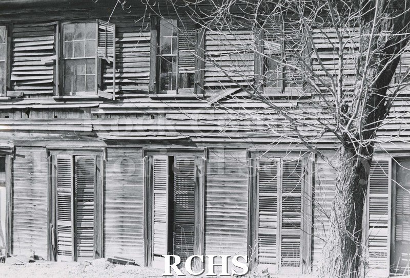 Black and white photograph of Hodson House, Shopiere Road. This is an abandoned two-story farm house showing the deterioration of the siding, windows and shutters.