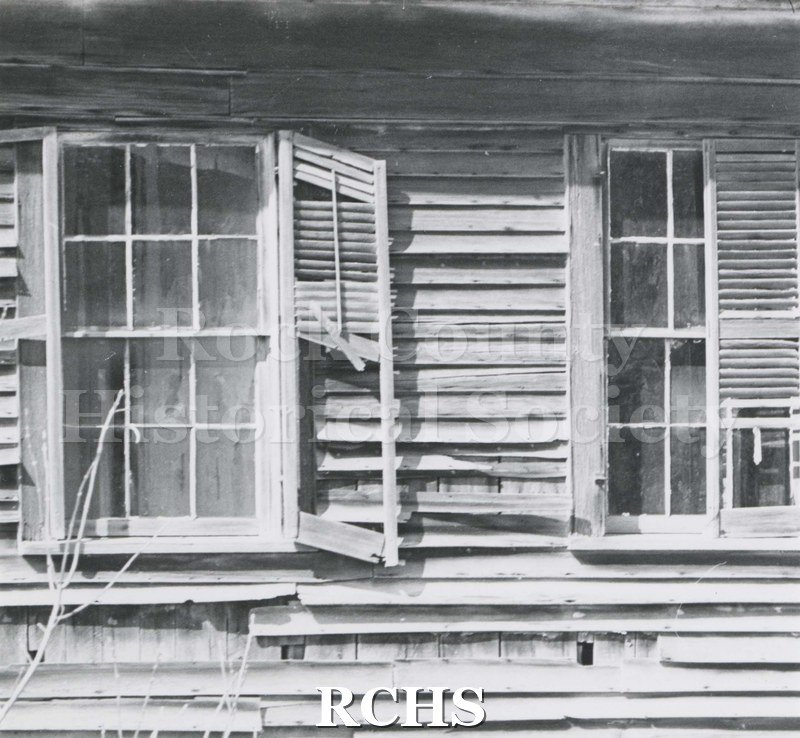 Black and white photograph of Hodson House, Shopiere Road. Shows two broken windows and broken shutters.