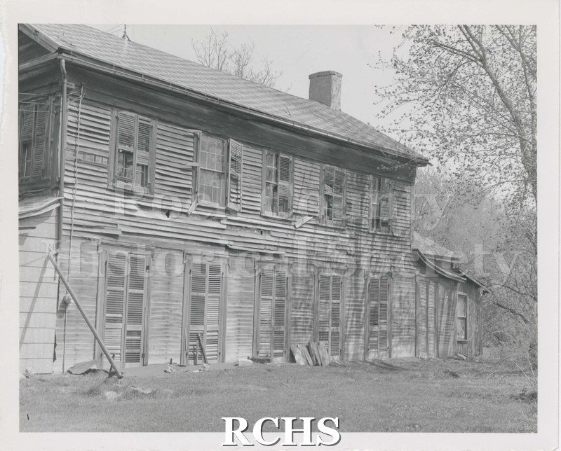 Black and white photograph of the Hodson House, Turtle Township, a two-story abandoned farm house, showing the deterioration to the siding, windows and shutters.