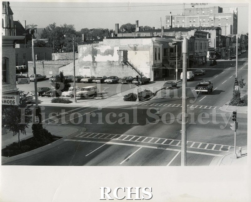 Black and white photograph of the intersection of Franklin and Milwaukee Streets in Janesville, WI. Hotel Monterey is visible in the distance.