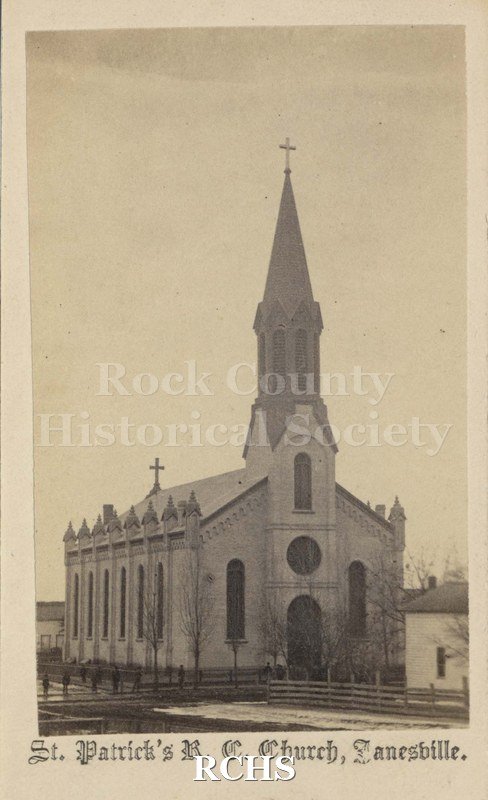 Tinted photo of St. Patrick's Church, Janesville, WI. Shows a church with a steeple with a cross on the top and a cross on the back. On bottom: "St. Patrick's R. C.