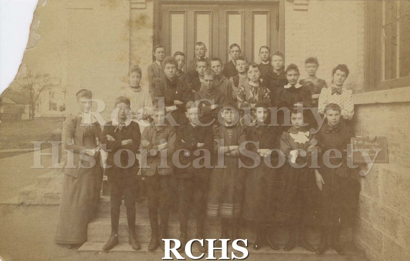 Black and white photograph of the 7th Grade Washington School, Janesville, WI. School children are standing in front of a building.