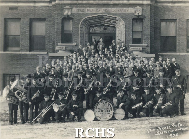 Black and white photograph of the Parker Pen Band on the steps of the Parker Pen Company. Drum reads: "Parker Pen Band Member A.F. of M. Local No.