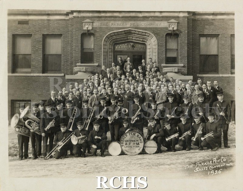 Black and white photograph of the Parker Pen Band on the steps of the Parker Pen Company. Drum reads: "Parker Pen Band Member A.F. of M. Local No.