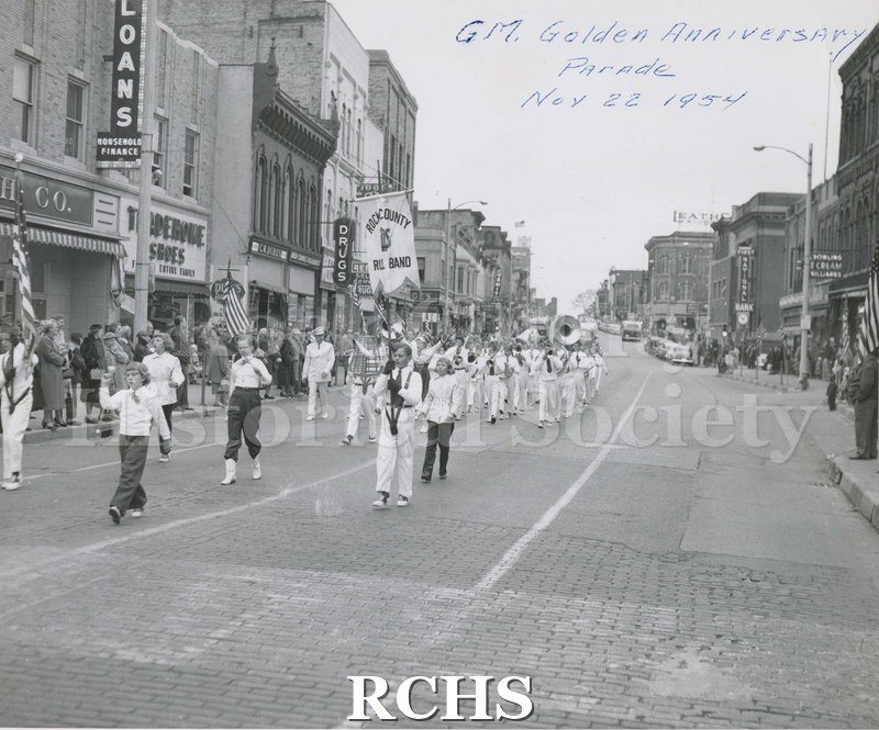 Black and white photograph of G. M. Golden Anniversary Parade 1954 down Main Street in Janesville, Wisconsin.