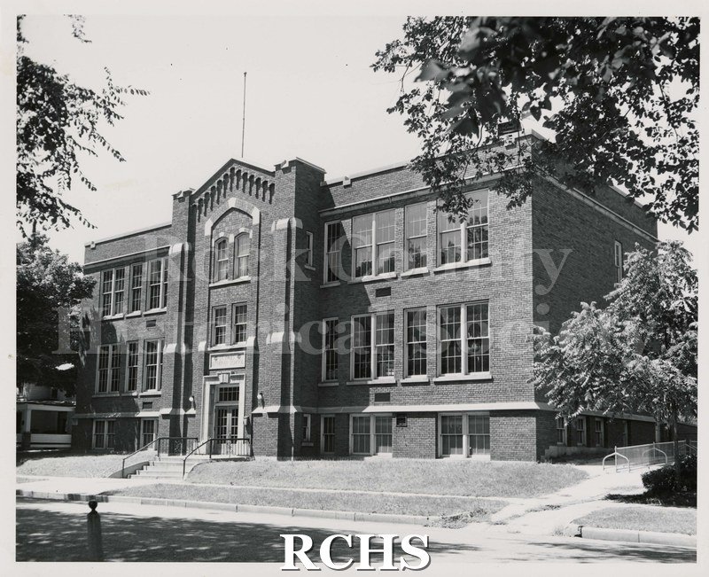 Black and white photograph of St. Paul's Lutheran School, Janesville, WI. Shows a two story brick school with a flagpole on top.
