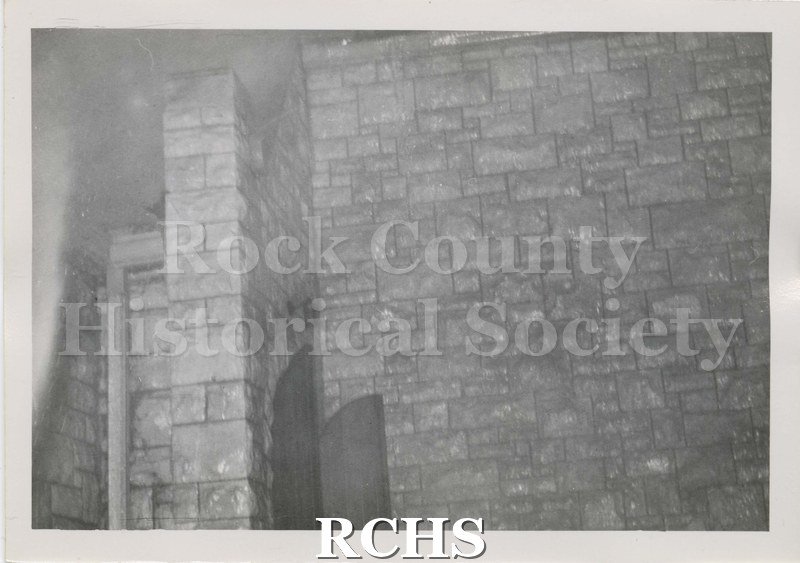 Black and white photograph of the fire at Beloit College Eaton Chapel. Close up of stone wall and dark marks on part. Possibly showing fire damage.