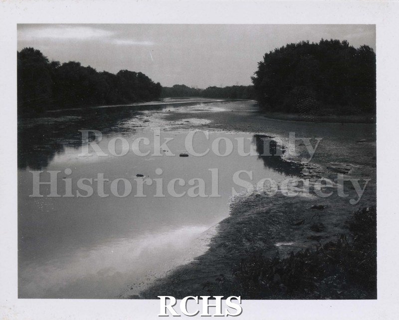 Black and white photograph of Rock River with trees on each side.