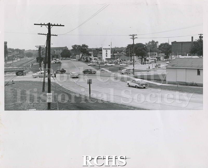 Black and white photograph of Centerway at Five Points, an intersection. In the background is a sign for "Torque Gas". "Standard" is on the right side.
