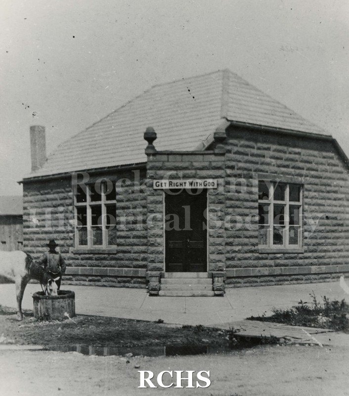 Black and white photograph of Howard's Mission, a brick building with "Get Right With God" above the door.