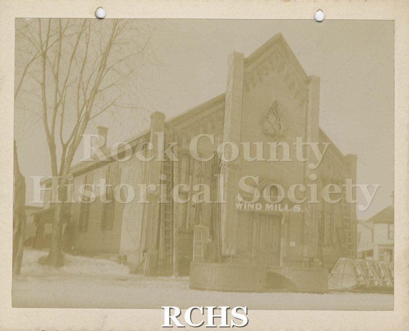 Black and white photograph of Old Presbyterian Church, Janesville, WI, with the words "The Wind Mills" over the door.