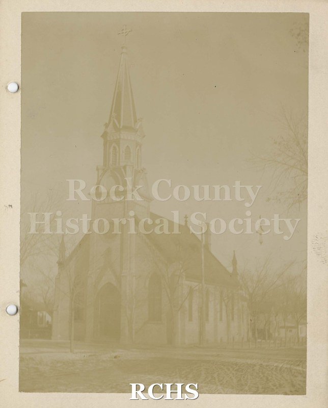 Black and white photograph of Scandinavian Lutheran Church, Janesville, WI, a wooden church with a round window above the door.