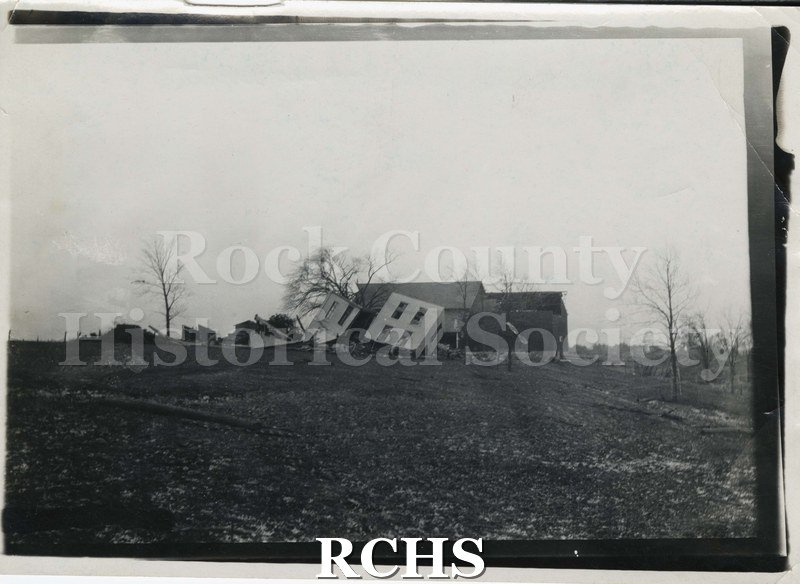 Black and white photograph of Sprackling farm damage. Shows a farm with house demolished but barn still standing after a tornado.
