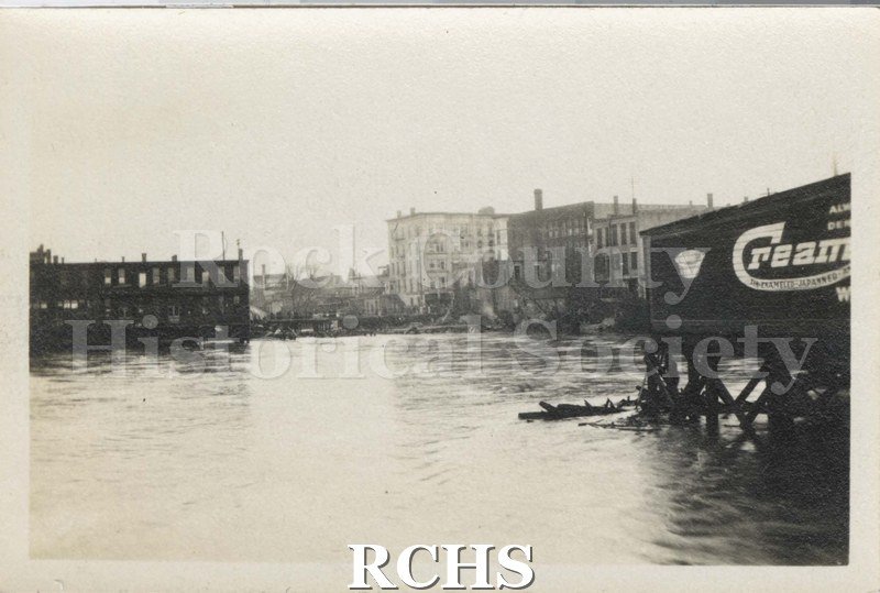 Black and white photograph of Milwaukee Street Fire 1913. Rock River is featured showing a building on the right with a sign that partially reads: "Cream".