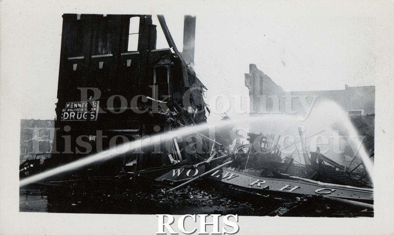 Black and white photograph of Milwaukee Street Bridge Fire, 1941. From left side and right side of photograph, a stream of water.