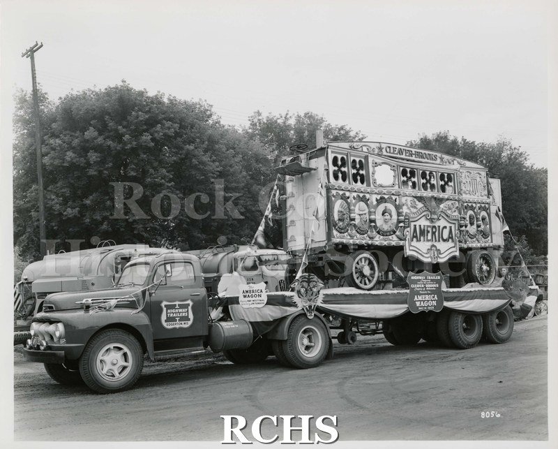 Black and white photograph of a circus wagon on a flat bed truck.