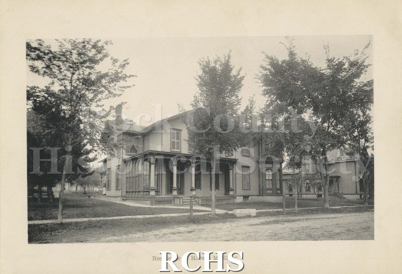 Black and white photograph of the residence of Horace McElroy. Shows a two story house with a pillared porch. On bottom: "Residence of Horace McElroy".