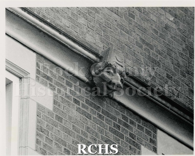 Black and white photograph of gargoyle on exterior of Janesville High School. Written on reverse: "Photographer: Duncan Pledger 1983".