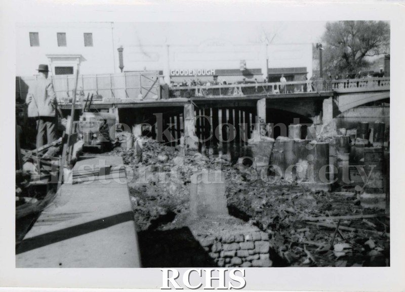 Black and white photograph of pilings left from the fire in the Rock River.