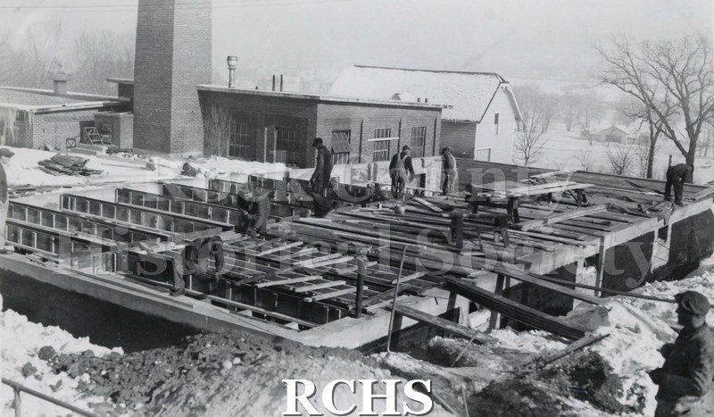 Black and white photograph of Mercy Hospital Laundry Addition under construciton. There are workmen on the site. On bottom: "Laundry Addition Mercy Hospital".