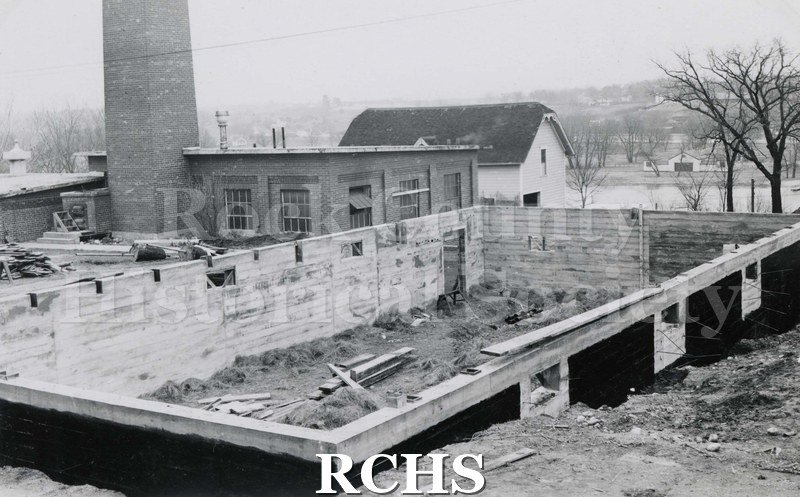 Black and white photograph of Mercy Hospital Laundry Addition under construction. The framework is up and there are boards in the middle of the building.