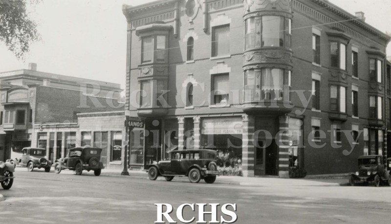 Black and white photograph of Kent Block, 50 S. Main, Janesville, WI. Shows a three story building on the corner of Milwaukee and Main St.