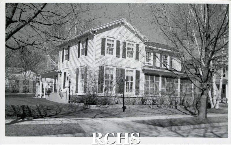 Black and white photograph of 210 S. Academy Street, a two story house with a back porch and enclosed front porch.