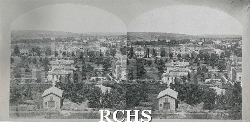 Black and white photograph of two photographs of Upper Court House Park looking toward the horizon. There are buildings and trees with a church in the distance.